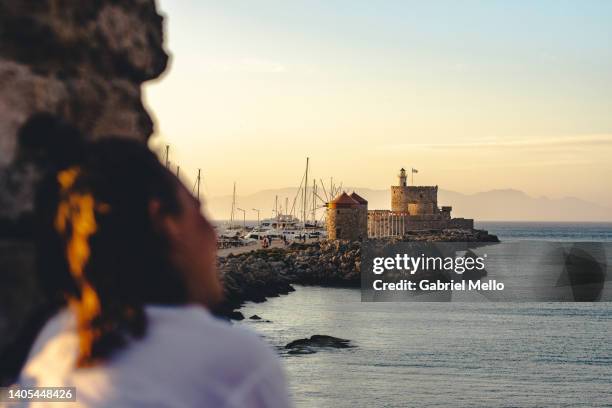 rear view of woman during sunset in the fortifications of rhodes - insel rhodos inselgruppe dodekanes stock-fotos und bilder