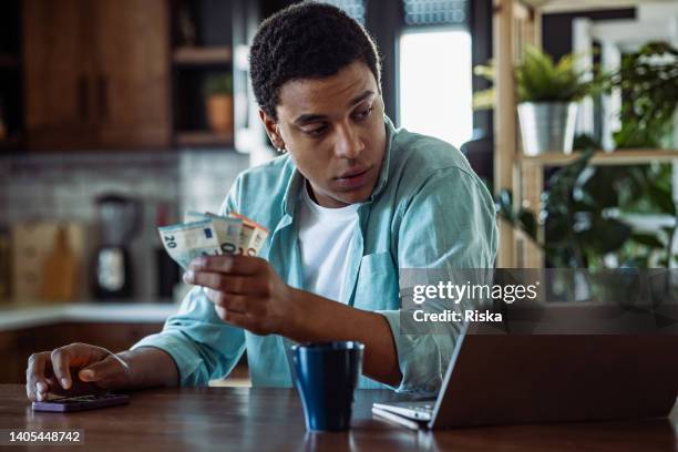 young man going through bills, looking worried - serbia eu stock pictures, royalty-free photos & images