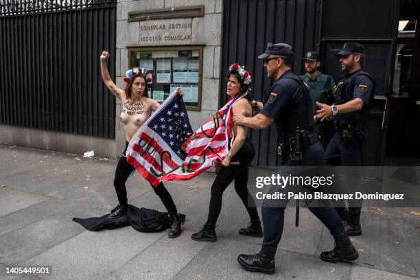 Activists with body paint reading 'Roe has fallen but we have not' hold an American flag reading 'Abortion is sacred' are disrupted by police...