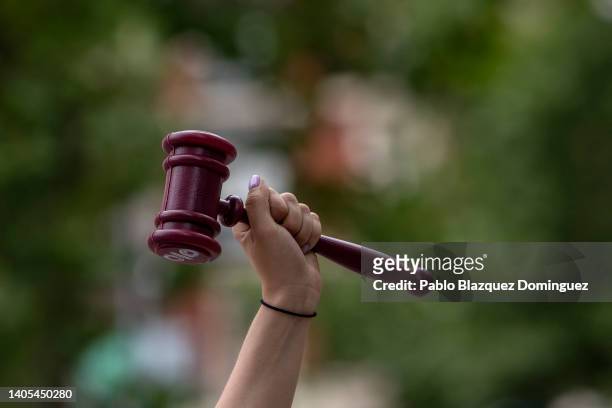 Activist rises her fist holding a toy gavel as she demonstrates outside the US Embassy against the US Supreme Court decision to overturn abortion...