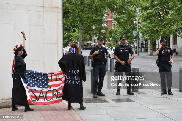 Three agents of the National Police and two members of Femen with a US flag during an action in front of the US embassy, June 27 in Madrid, Spain....
