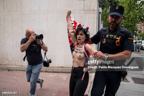 Activist with body paint reading 'Roe has fallen but we have not' protests as a police officer leads her away outside the US Embassy against the US...