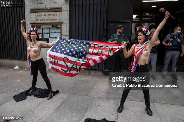 Activists with body paint reading 'Roe has fallen but we have not' hold an American flag reading 'Abortion is sacred' as they demonstrate outside the...