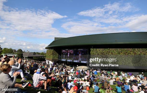 Spectators watch the Women's Singles First Round match between Emma Raducanu of Great Britain and Alison Van Uytvanck of Belgium on Murray Mound...