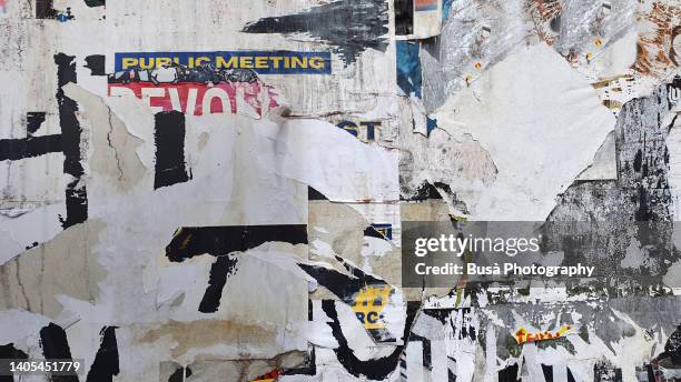 scratched layers of posters and placards on a street wall in dalston, london, england, uk - posters and propaganda stock pictures, royalty-free photos & images