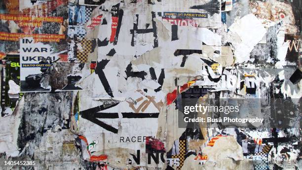 scratched layers of posters and placards on a street wall in dalston, london, england, uk - affiche mur photos et images de collection