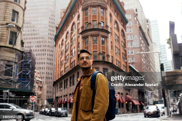 portrait of a young man in eyeglasses on the street in new york city, usa - york city foto e immagini stock