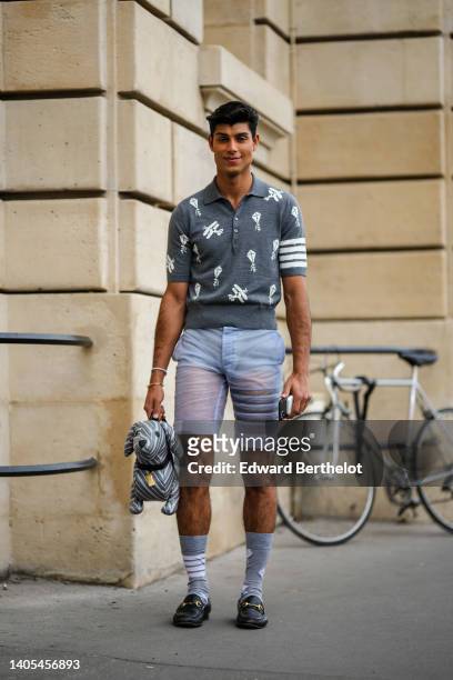 Guest wears a gray with white print pattern short sleeves polo shirt, a white pearls bracelet, a gold Juste Un Clou bracelet from Cartier, pale blue...
