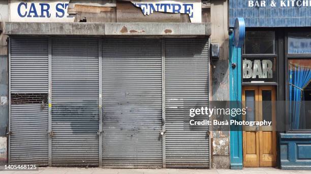 shut down metal grate and store front of bar in dalston, hackney. london, england - fermé photos et images de collection