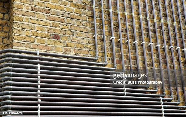 metal ducts and pipes on brick wall. - london tube photos et images de collection