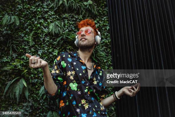 interesting-looking gay man listening to music and dancing - eccentric people stock pictures, royalty-free photos & images