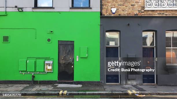 composition of facades with grey, lime green paint and brick - awning window fotografías e imágenes de stock