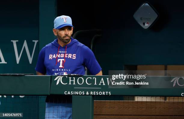 Manager Chris Woodward of the Texas Rangers looks on from the team dugout against the Washington Nationals at Globe Life Field on June 26, 2022 in...