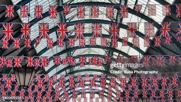 british flags hanging from glass ceiling inside covent garden, london, england - brexit travel stock pictures, royalty-free photos & images