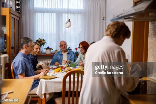 grandma cooking dinner, family enjoying delicious first course at the dining table - thanksgiving pets stock pictures, royalty-free photos & images