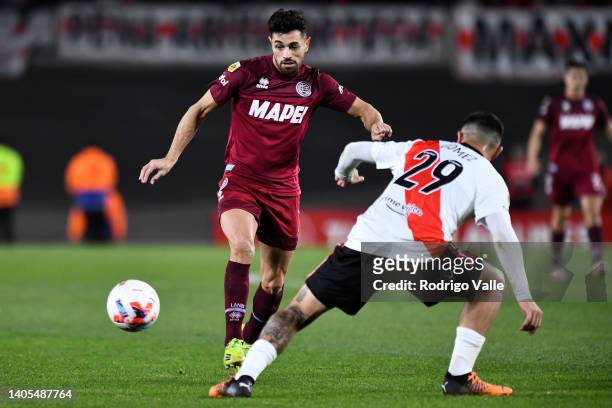 Lautaro Acosta of Lanus drives the ball against Elias Gomez of River Plate during a match between River Plate and Lanus as part of Liga Profesional...
