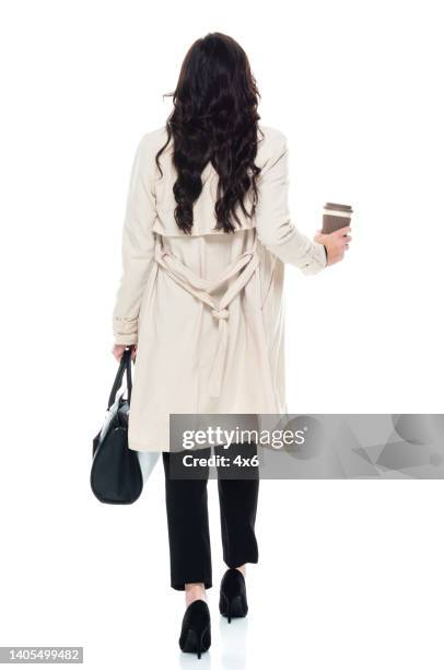 caucasian young women business person walking in front of white background wearing businesswear and holding coffee cup - woman front and back stockfoto's en -beelden