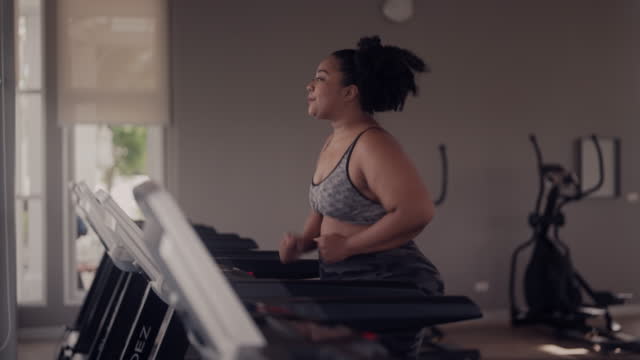 Plus size woman jogging on treadmill