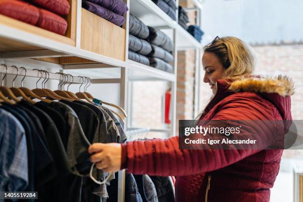 woman buying/choosing clothes - sportswear shopping stockfoto's en -beelden