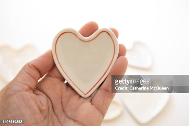 black woman holding ceramic heart - emotional intelligence stock pictures, royalty-free photos & images
