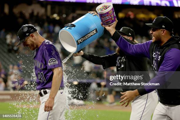 Starting pitcher Chad Kuhl of the Colorado Rockies is douched with water and candy by Charlie Blackmon and Carlos Estevez after pitching a complete...
