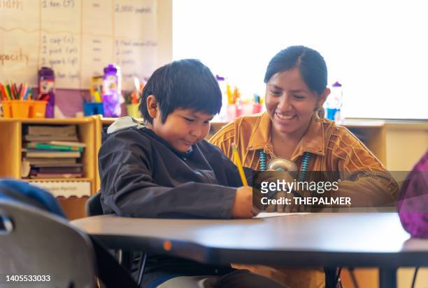 hilfsbereite lehrerin, die einen ihrer schüler ermutigt - navajo stock-fotos und bilder