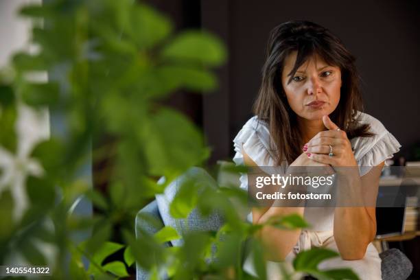 donna preoccupata che guarda in basso, che si spezza le nocche nervosamente, meditando - nocca foto e immagini stock