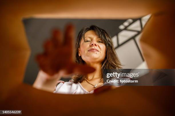 businesswoman smiling at camera while reaching her hand in a brown paper bag - bag 個照片及圖片檔