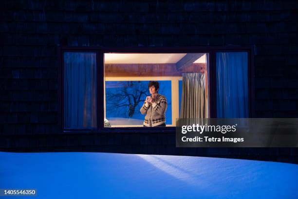 woman looking through window at dusk in winter - chester see stock pictures, royalty-free photos & images