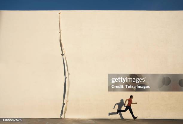 man escaping by climbing rope over wall - prison escape stock pictures, royalty-free photos & images