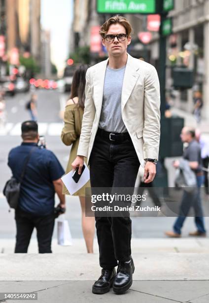 Guest is seen wearing a cream blazer, gray shirt, black pants and black shoes outside the Marc Jacobs show on June 27, 2022 in New York City.