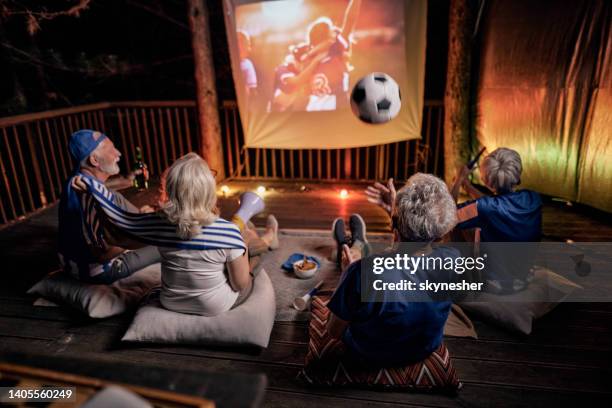 beobachten sie ein erfolgreiches fußballspiel auf der terrasse bei nacht! - fußball fan oma stock-fotos und bilder