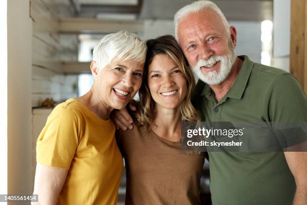 porträt glücklicher älterer eltern und ihrer erwachsenen tochter zu hause. - adult children with parents stock-fotos und bilder