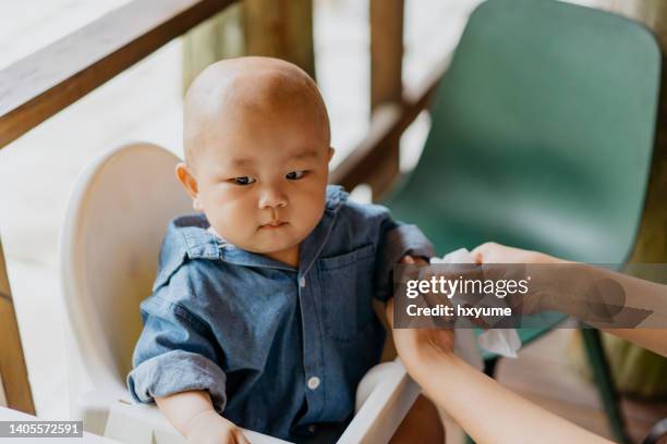 mother cleaning hand of her baby with wet wipe - antiseptic wipe stockfoto's en -beelden