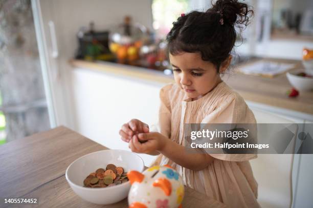 little multiracial girl saving her money for toys. - financial literacy stock pictures, royalty-free photos & images