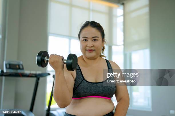 plus size woman is exercising at sport club. - asian female bodybuilder 個照片及圖片檔