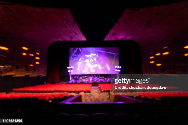 defocused image of empty cinema with empty seats and concert stage - feierliche veranstaltung stock-fotos und bilder
