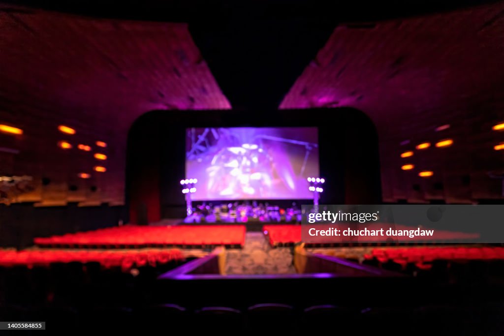 Defocused Image Of Empty Cinema with Empty seats and concert stage