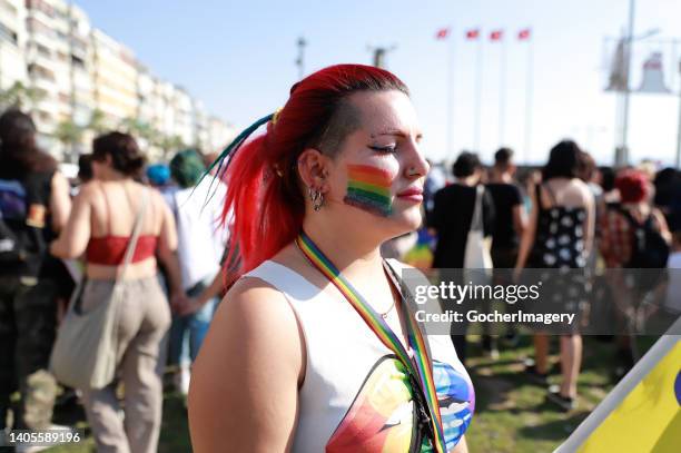 Member of the LGBT community paints a rainbow flag on her face during the 10th Izmir LGBTI+ Pride March in Izmir, Turkey, on Sunday, June 26, 2022.