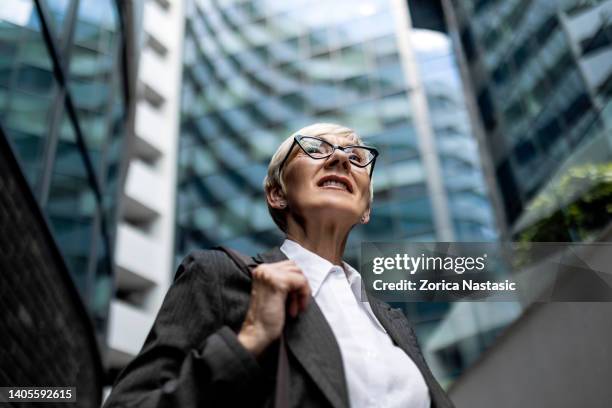 mature businesswoman - looking up at buildings stock pictures, royalty-free photos & images