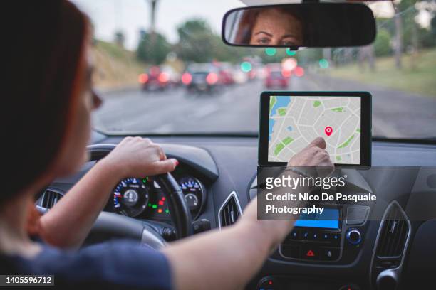 woman sitting in car and using navigation system - automotive navigation system stock pictures, royalty-free photos & images