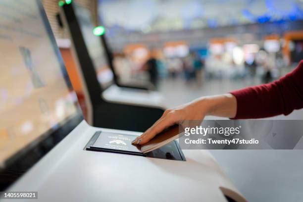 asian woman wearing a face mask self-check-in by kiosk machine in the airport - passport open stock pictures, royalty-free photos & images
