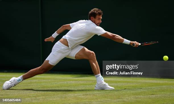 Henri Laaksonen of Switzerland plays a backhand against Ryan Peniston of Great Britain during their Men's Singles First Round Match on day two of The...