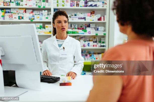 pharmacist explaining quantity of medication consumption to client - pharmacist explaining stock pictures, royalty-free photos & images