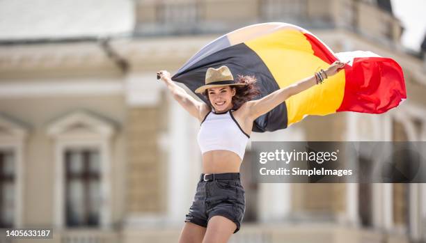 belgian flag in the hands of a young tourist in summer clothes - festa nazionale foto e immagini stock