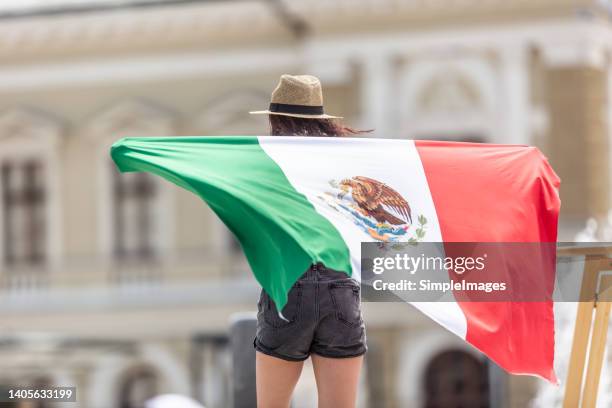 hispanic tourist with mexican flag, rear view. - heritage month stock pictures, royalty-free photos & images