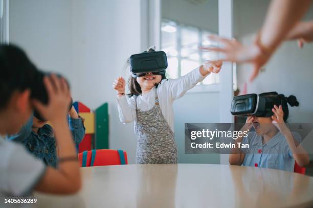 exciting asian chinese preschool students enjoying having fun time with vr google in classroom - classroom wide angle stock pictures, royalty-free photos & images