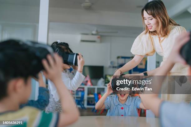 exciting asian chinese preschool students enjoying having fun time with vr google in classroom - classroom wide angle stock pictures, royalty-free photos & images