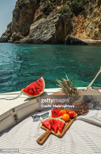 wassermelonen- und obstpicknick auf dem boot in der griechischen lagune - picknick edel stock-fotos und bilder
