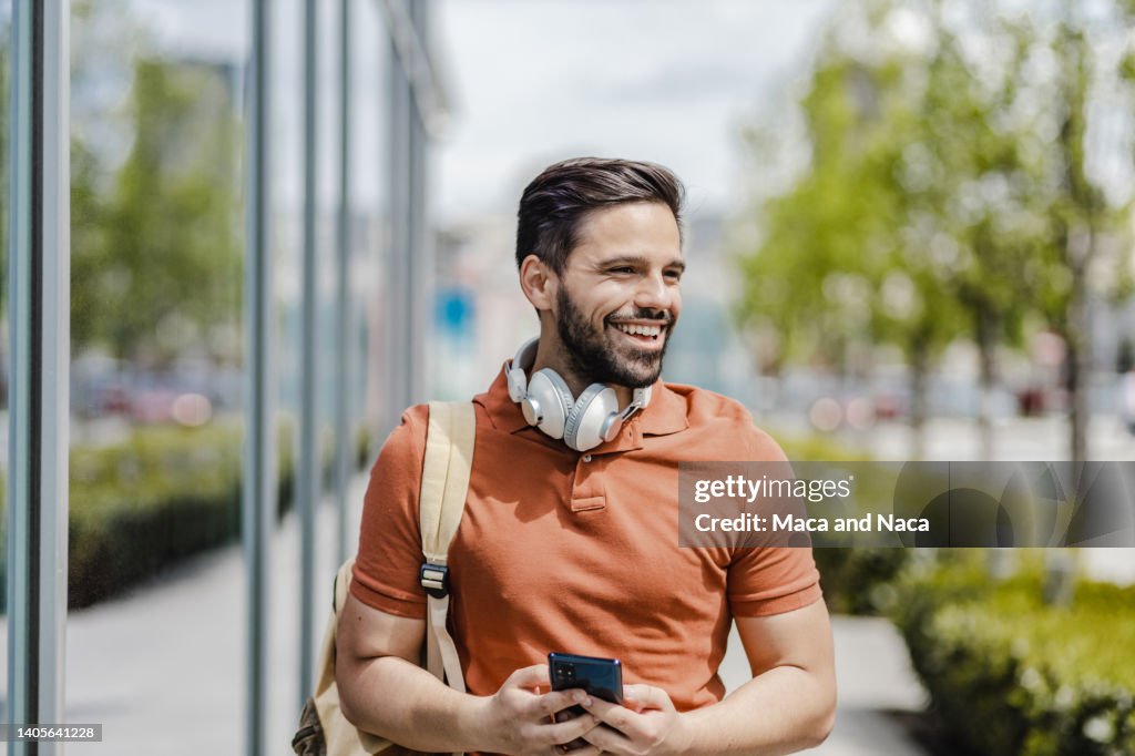 Retrato de un joven sonriente caminando por la calle